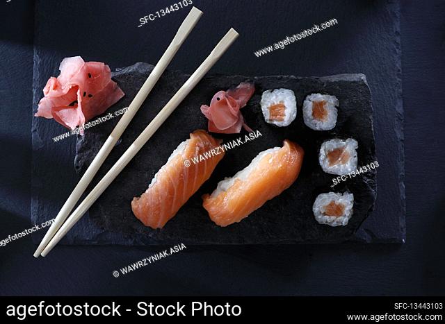 Nigiri sushi and hosomaki sushi rolls with fresh salmon fillet