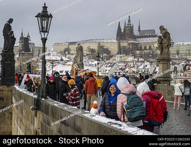 People on the Charles Bridge in Prague, Czech Republic, on November 26, 2023.On the background is seen the Prague Castle with St. Vitus Cathedral