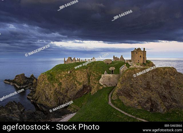 Menacing dark clouds above Dunnottar Castle, ruined medieval fortress near Stonehaven on cliff along the North Sea coast, Aberdeenshire, Scotland