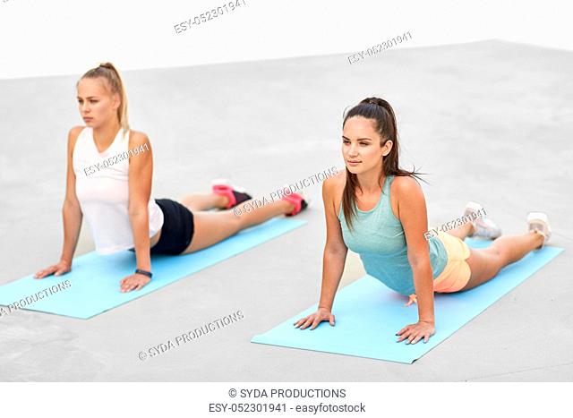 women doing sports on exercise mats outdoors