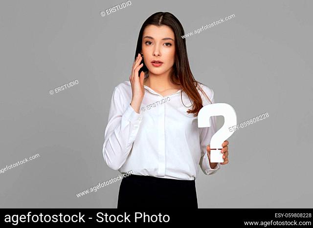 beautiful caucasian business woman with question mark on gray background