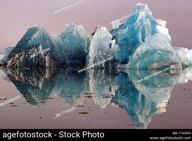 Blue iceberg reflected in smooth water, Jökulsarlon, glacier lagoon, Scandinavia, Iceland, Europe