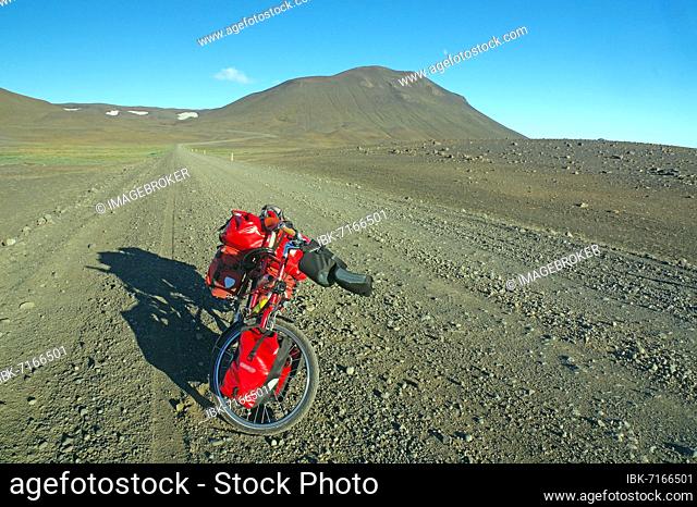 Loaded bicycle on rough track in barren, stony landscape, semi-desert, Mödrudalur, East Iceland, Iceland, Europe