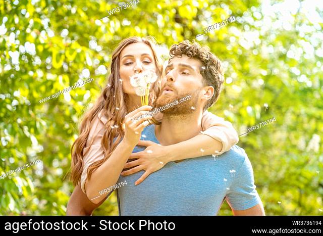Woman and man on a meadow in romantic mood enjoying themselves and their life