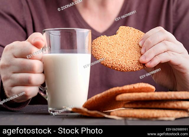 Breakfast with Round cookie with sesame seeds and cup of milk