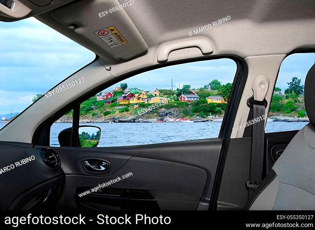 Looking through a car window with view over colorful houses on the shore of Oslo fjord, Oslo, Norway