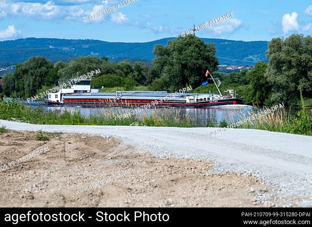 06 July 2021, Bavaria, Reibersdorf: A ship sails on the Danube. The federal waterway between the Straubing lock and the Bogen railway bridge is being expanded