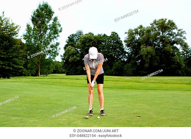 Frau spielt Golf auf einem Golfplatz im Sommer