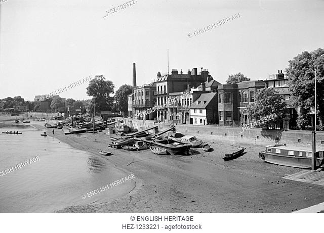 Shore of the Thames at Hammersmith, London, c1945-1965. An elevated view looking at water vessels beached on the foreshore of the Thames at low tide
