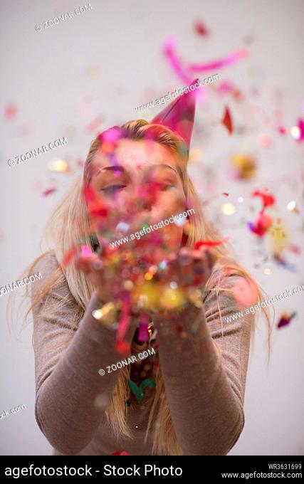 Beautiful woman blowing confetti in the air party new years eve celebration isolated on white background