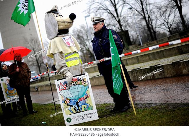 The macot of the Trade Union of the Police talks to a police officer during a vigil in front of the state parliament in Duesseldorf, Germany, 20 March 2013