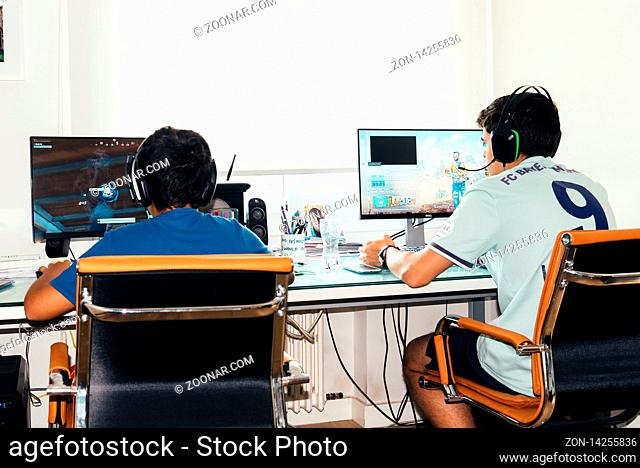 Madrid, Spain - August 23, 2019: Teenagers playing Fortnite video game and CSGO Counter Strike on PC. Fortnite is an online multiplayer video game developed by...