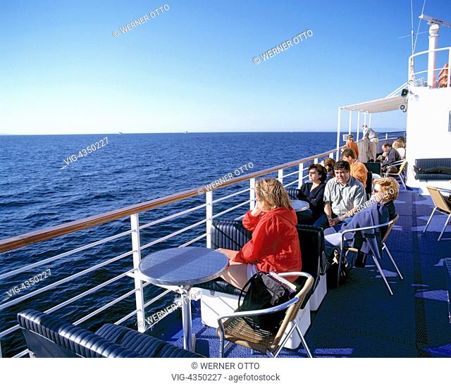 Tourismus, Kreuzfahrt, Kreuzfahrtschiff, Touristen sitzen an der Reling und blicken auf das Meer, Griechenland, Aegaeis, Aegaeisches Meer, Mittelmeer