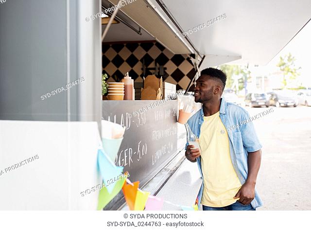 african american man with drink at food truck