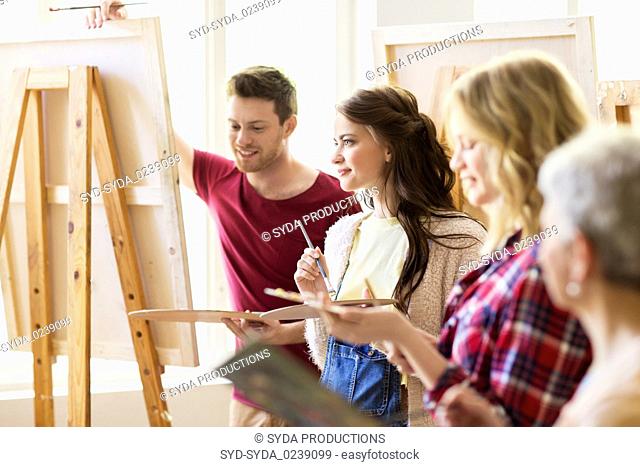 group of young artists painting at art school