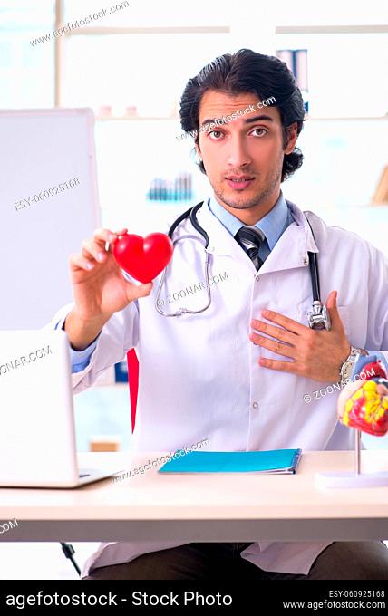 Young handsome doctor cardiologist in front of whiteboard