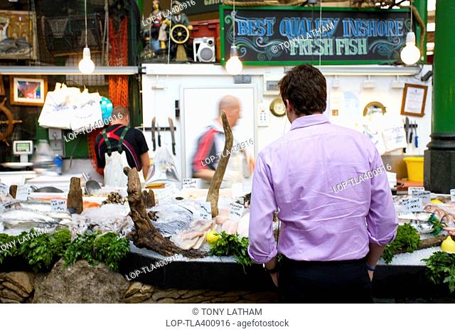 England, London, Borough, A customer at a fresh fish stall in Borough Market