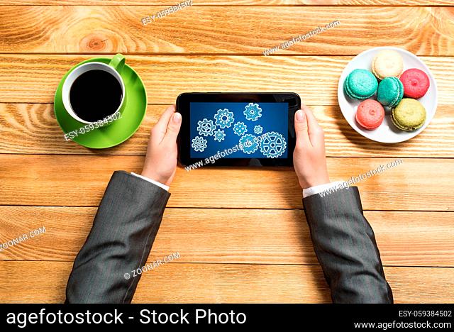 Top view of businesswoman sitting at table and using tablet