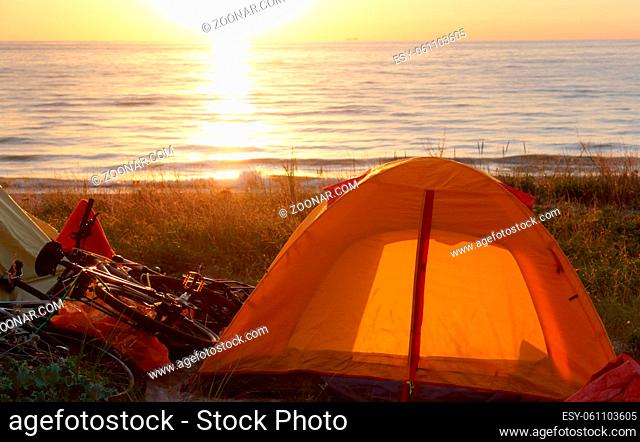 yellow tent on the beach, tourist camping on the sand by the sea
