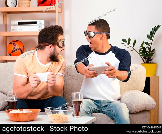 Picture of happy friends playing computer games. Handsaome men screaming and shouting, looking at each other during plating games