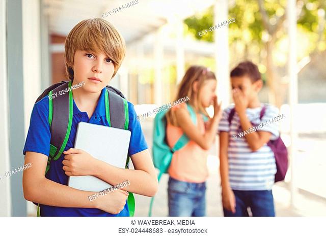 School friends bullying a sad boy in corridor