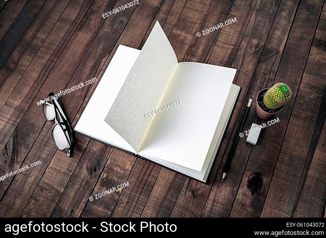 Opened blank book, stationery on wooden background. Notebook, glasses, pencil, eraser and cactus