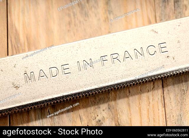 Made in France engraved on steel tool on wooden table. Close up