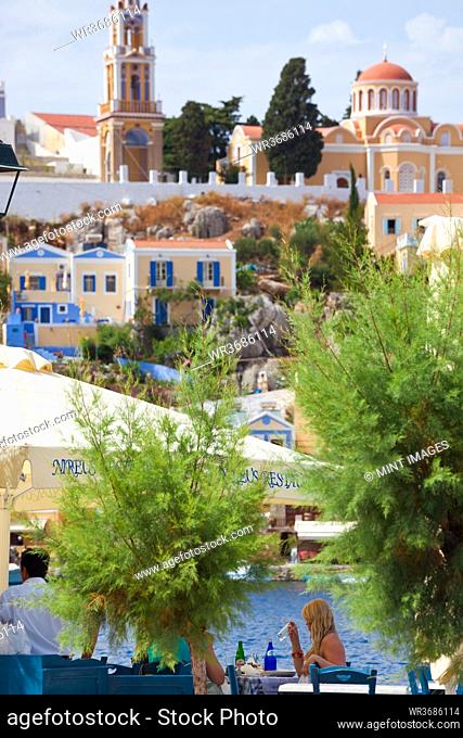 Symi Town, elevated view, rooftops, terraces, restaurant, people in the background