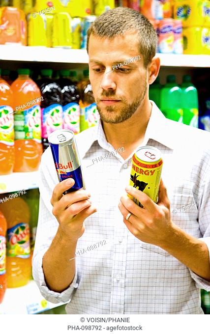 Man shopping for energy drinks in supermarket