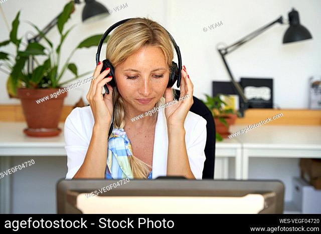 Female customer service representative wearing headphones at office