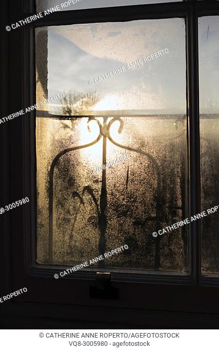 Sunrise and shadows through a misty window pane and decorative ironwork balcony over the harbour, Hotwells, Bristol