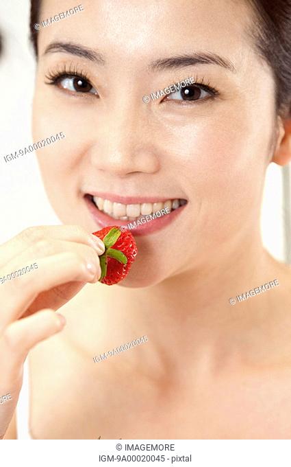 Beauty Treatment, Close-up of woman eating strawberry with smile