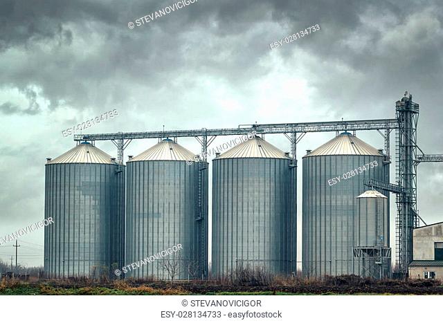 Grain silos for harvest storage on cloudy day, bad weather forecast