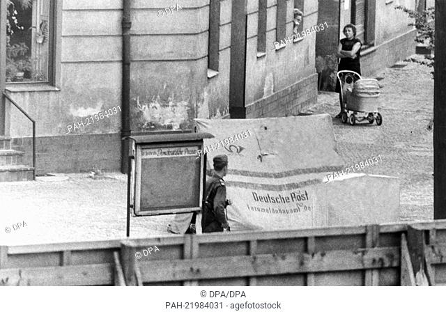 Border guards watching the opening of an incomplete escape tunnel to West Berlin. They disguised as post office clerks but were unmasked because of their boots