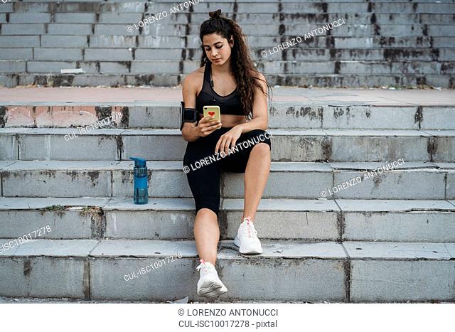 Young woman using smartphone on stairways