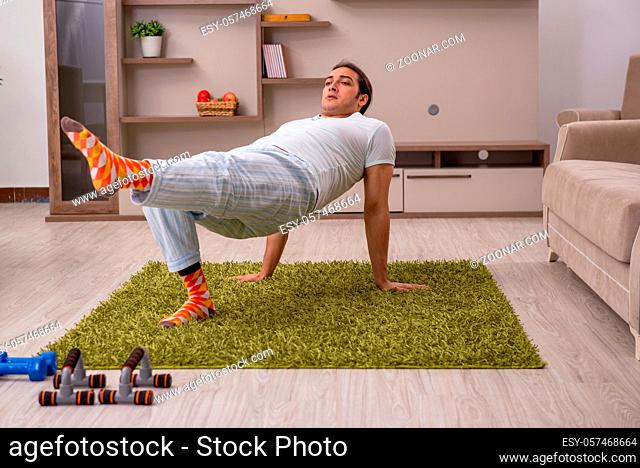 Young man doing sport exercises indoors