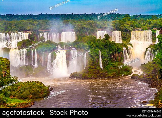 Boiling water creates a watery dust and a rainbow. Several waterfalls from Iguazu Falls. The concept of extreme and exotic tourism
