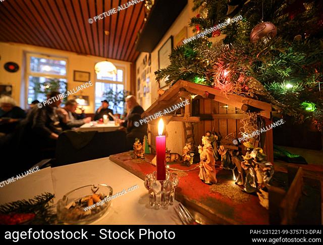 PRODUCTION - 21 December 2023, Schleswig-Holstein, Kiel: A small decorated Christmas tree with a nativity scene stands on a table in the ""Kieler Anker"" social...