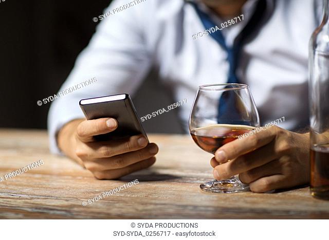 close up of man with smartphone and alcohol