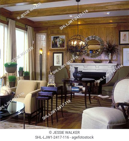 LIVING ROOMS - Stately, eclectric room, paneled walls, fireplace, round mirror, modern art, wheat grass in containers. Exposed beams, Baker furniture, area rug