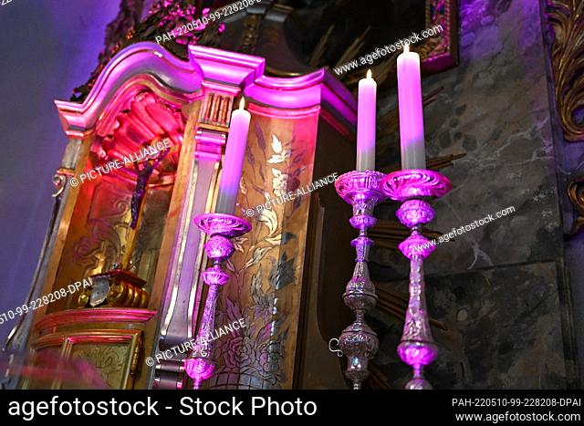 09 May 2022, Baden-Wuerttemberg, Litzelstetten: The altar including the tabernacle of the churches of Saint Peter and Paul is illuminated in pink during the...