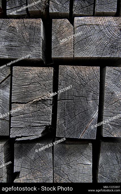 Faded, stacked wooden slats against a black background