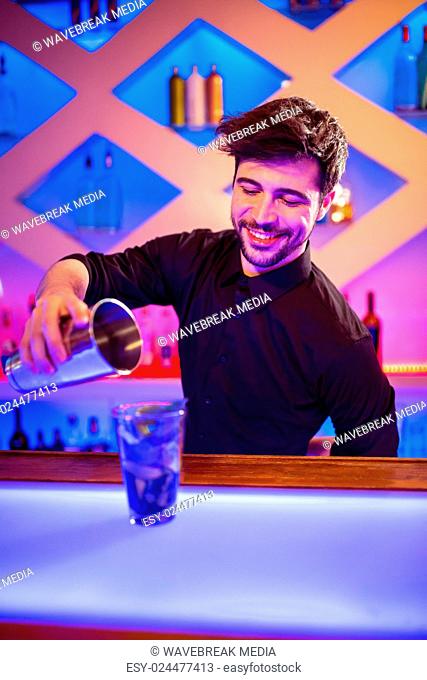 Bartender pouring cocktail in glass