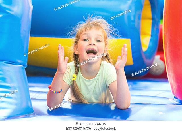 Happy girl lying on a big inflatable trampoline game