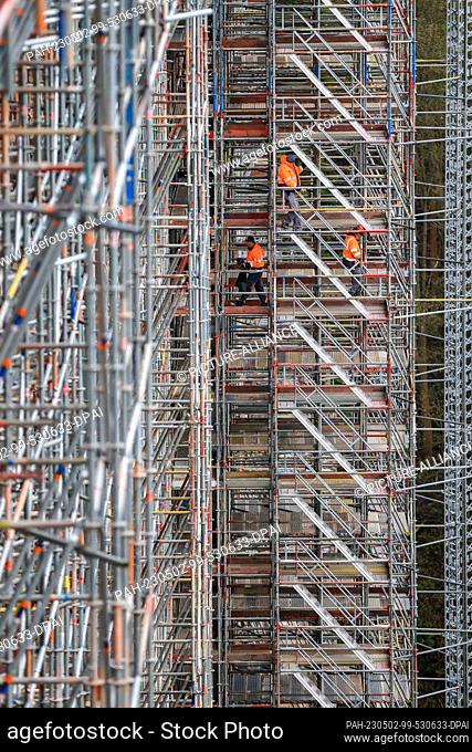 02 May 2023, Saxony, Jocketa: Construction workers walk over the scaffolding on the more than 150-year-old Elster Valley Bridge in the Vogtland region