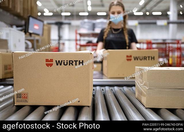 11 May 2022, Baden-Wuerttemberg, Kupferzell: An employee of the Würth trading group processes shipments of goods in a logistics center