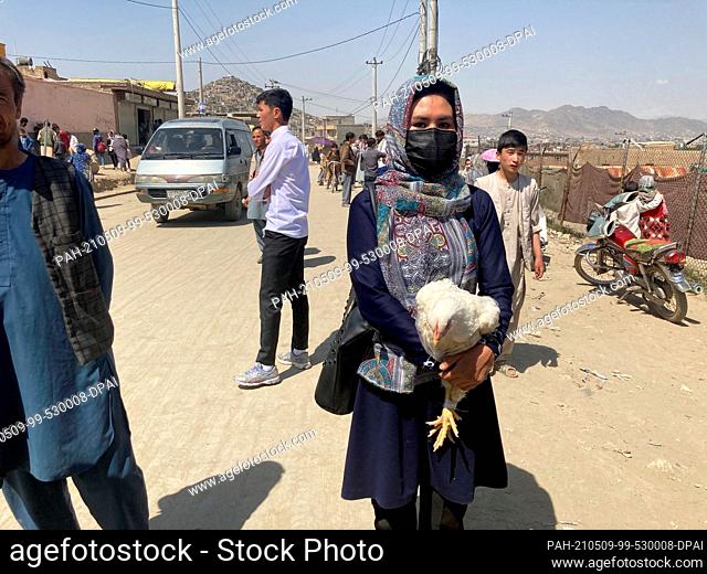09 May 2021, Afghanistan, Kabul: Hasiba, a 20-year-old Afghan woman who lives near the site of the attack, walks down a street