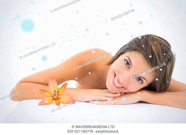 Composite image of close up portrait of a beautiful young woman on massage table