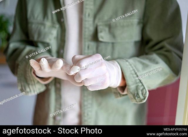 Man putting on protective gloves