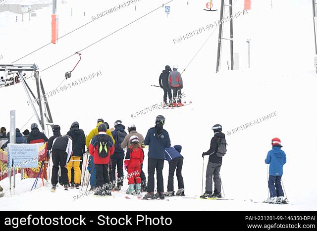 01 December 2023, Saxony, Altenberg: Winter sports enthusiasts wait at a ski lift at the foot of the Altenberg Adventure Mountain ski resort
